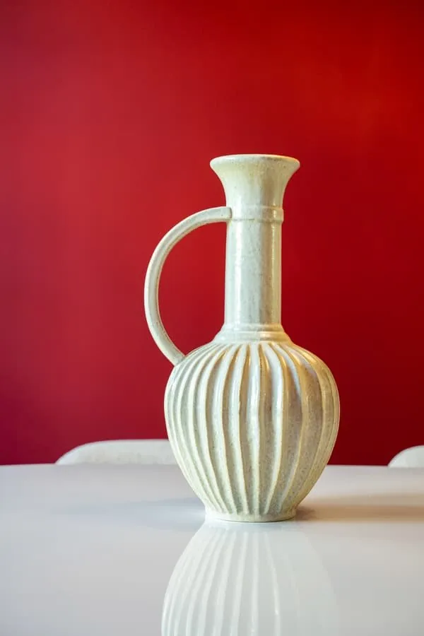 A ceramic jug against the red wall