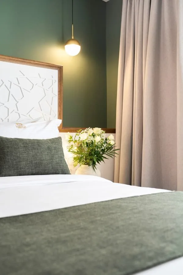 A bed against the green wall